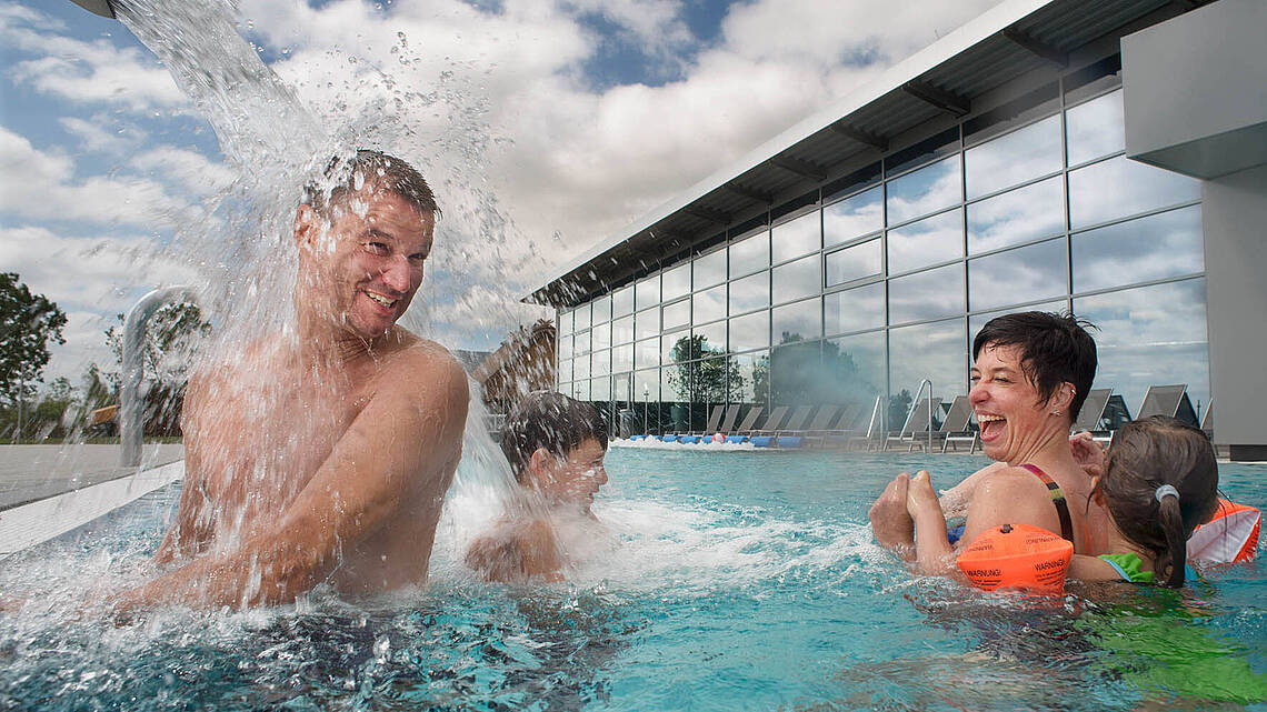 Eltern und Kinder planschen gemeinsam im Aussenpool