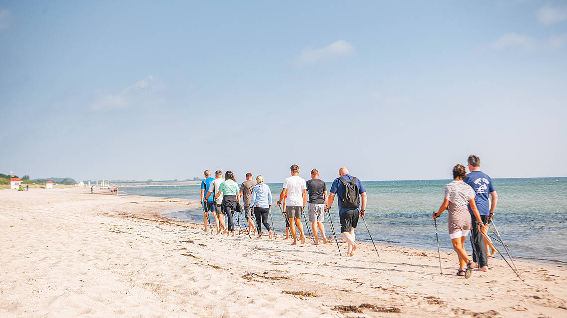 Eine Gruppe beim Nordic Walking am Strand